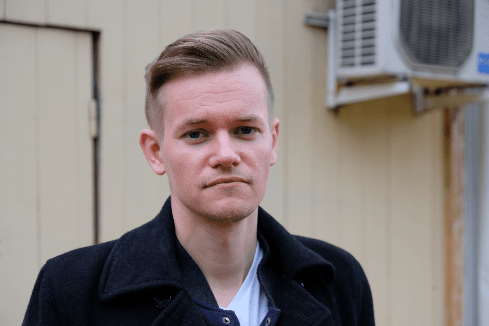 Joakim Medin sarı bir ahşap duvarın önünde çekildiği fotoğraf.